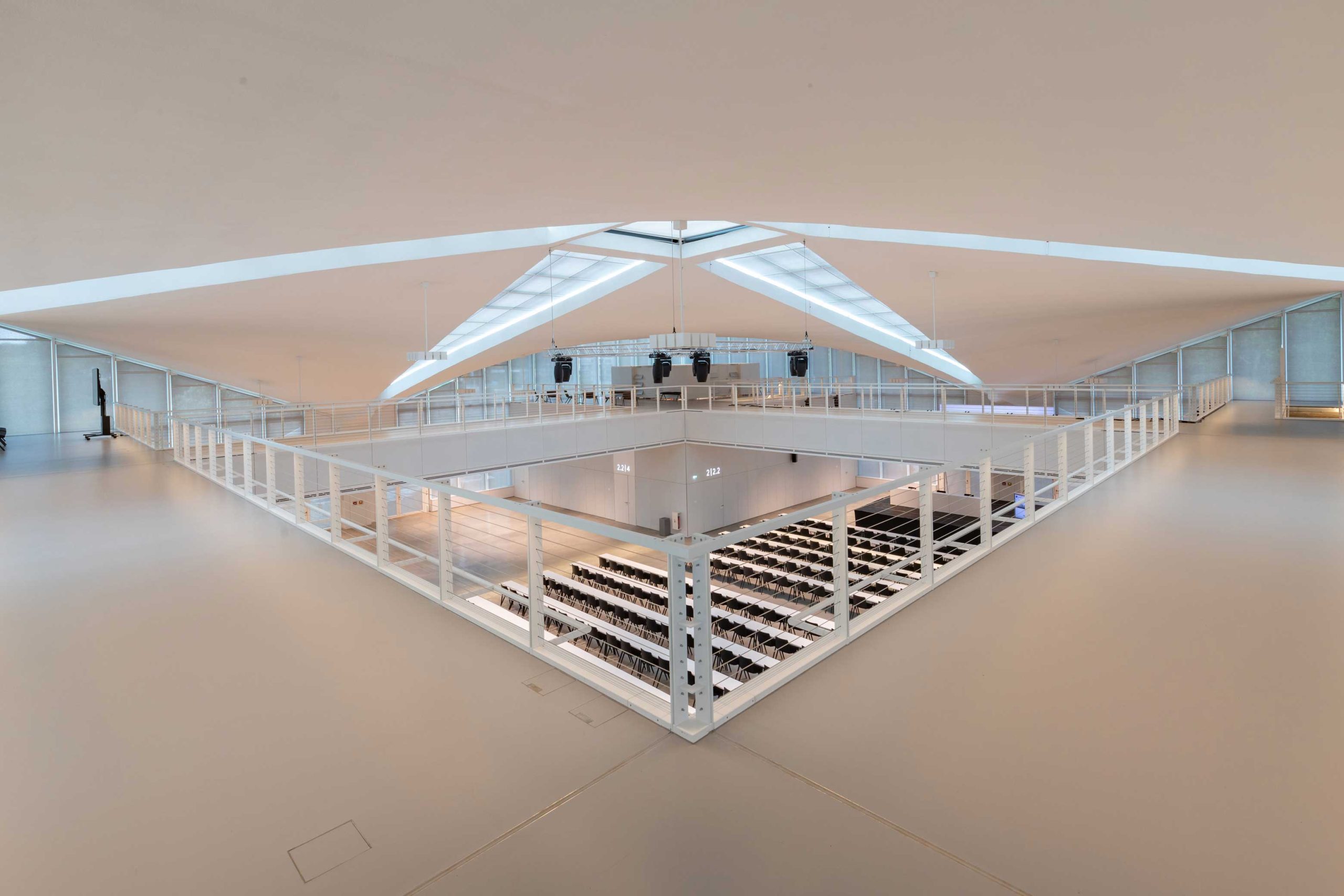 Innenraum der Hyparschale Magdeburg mit modernisiertem Veranstaltungsbereich und offener Lichtarchitektur.